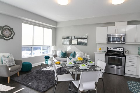 a kitchen and living room with a glass table and chairs